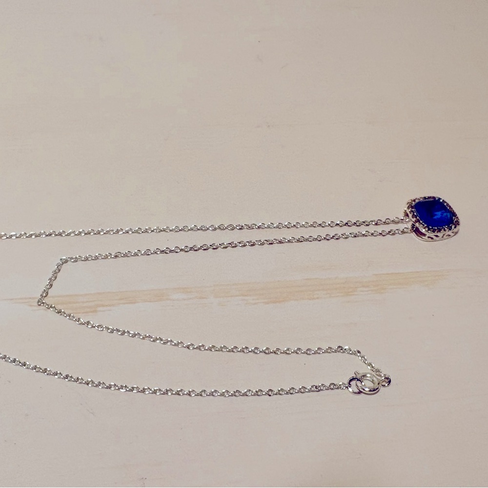 Silver tone costume necklace with blue stone.
